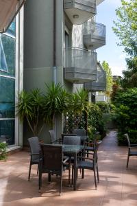 a patio with a table and chairs and a balcony at Residence Villa Azzurra in Rimini
