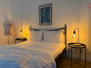 a bedroom with a bed with white sheets and two lamps at Casa Gaudia Varese living-working e quiete in Barasso