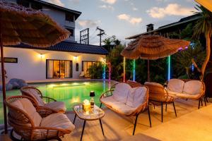 a patio with chairs and a pool in front of a house at Palmcove Chiang Mai Old Town in Chiang Mai