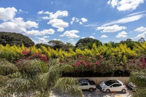two cars parked in a parking lot with flowers at Estudio232 - Asa Sul in Brasília