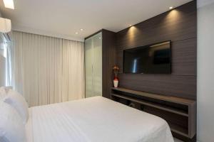 a bedroom with a bed and a flat screen tv at Estudio232 - Asa Sul in Brasília