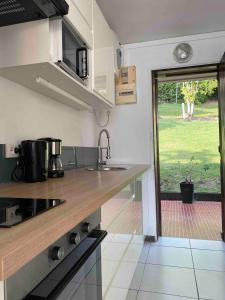 a kitchen with a counter and a view of a yard at Bleu Caraibe studio in Schœlcher