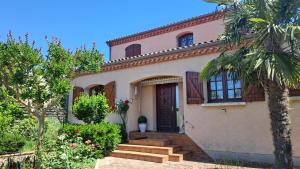 a house with a palm tree in front of it at Chez tatie Jacqueline in Albi