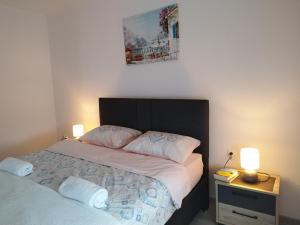 a bedroom with a bed with two lamps on it at Apartment White Rose in Bar