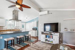 a kitchen with white cabinets and a ceiling fan at Sea Glass Shack in Kill Devil Hills