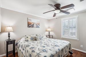 a bedroom with a bed and a ceiling fan at Sea Glass Shack in Kill Devil Hills
