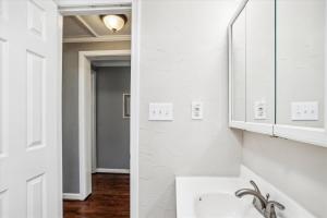 a white bathroom with a sink and a mirror at Sea Glass Shack in Kill Devil Hills +31 photos