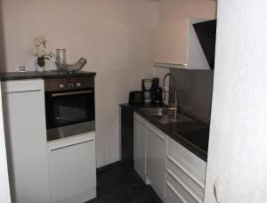 a small kitchen with white cabinets and a sink at EXCELSIOR Apartments Rovinj in Rovinj