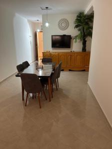 a dining room with a table and chairs and a television at Appartement Berkane in Berkane