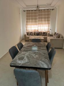 a dining room with a table and a couch at Appartement Berkane in Berkane