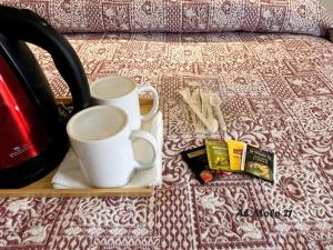 a tray with two cups and a book on a bed at Al molo 21 in La Spezia