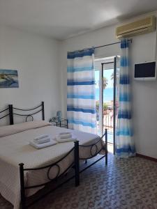 a bedroom with two beds and a view of the ocean at Hotel Le Onde in Terracina