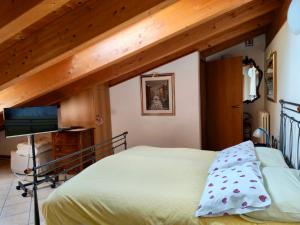a bedroom with a bed and a tv in a room at Camera Lucy in Bardolino