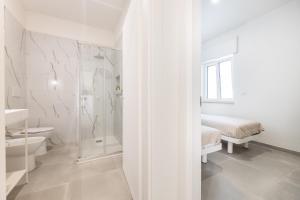 a white bathroom with a shower and a sink at Appartamenti Mancaversa in Marina di Mancaversa +33 photos