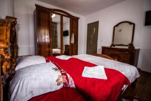 a bedroom with a bed with a red blanket at Cabana La Cucu in Vadu Moţilor