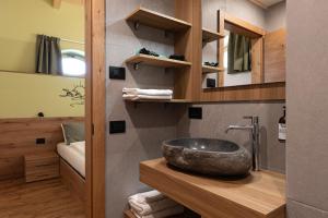 a bathroom with a stone sink in a room at Palazzo Tamanini in Calceranica al Lago +24 photos