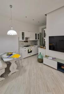 a large white kitchen with a table and a tv at Marè Sunrise in Bari