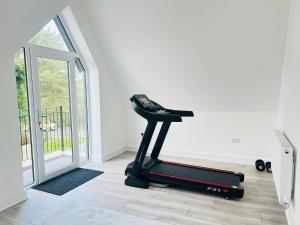 a treadmill in a living room next to a door at Luxurious New Home Near Airport in Wythenshawe