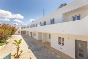 an empty courtyard of a building with white buildings at Appartamenti Mancaversa in Marina di Mancaversa