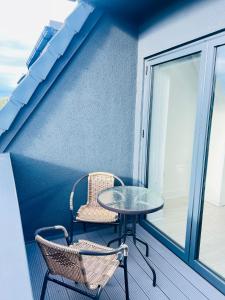 a table and two chairs sitting on a balcony at Luxurious New Home Near Airport in Wythenshawe