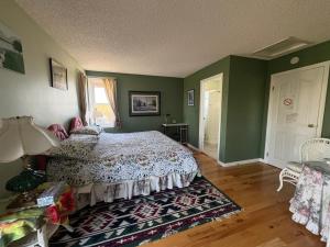 a bedroom with a bed and green walls at Tudor House Bed and Breakfast in Bottrel