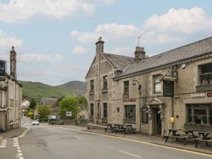 a street in a town with two stone buildings at The Toll Bar in Castleton