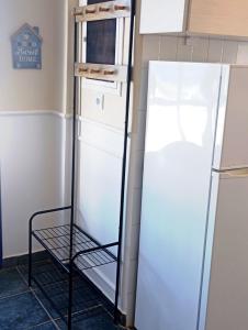 a refrigerator in a kitchen with a shelf next to it at Prasonisi villas in Karpathos