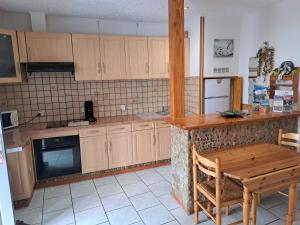 a kitchen with wooden cabinets and a wooden table at Studio cosy entre Mer, Espagne & Montagne in Peyrestortes