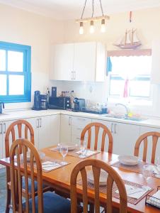 a kitchen with a wooden table with chairs and a table and a table and chairs at Prasonisi villas in Karpathos
