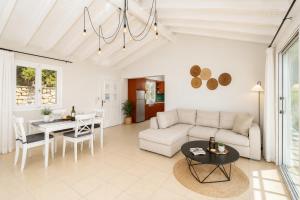a living room with a couch and a table at Villa Bougainvillea in Vlachopoulátika