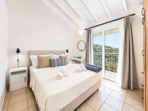 a bedroom with a large bed and a large window at Villa Bougainvillea in Vlachopoulátika +11 photos