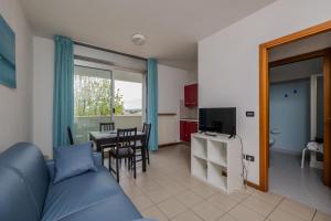 a living room with a blue couch and a dining room at Residence Villa Azzurra in Rimini