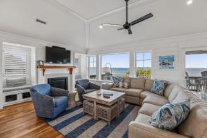 a living room with a couch and chairs and a fireplace at Knot for Sail in Duck