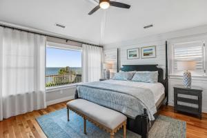 a bedroom with a bed and a large window at Knot for Sail in Duck