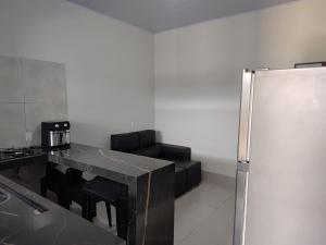 a kitchen with a black counter and a refrigerator at Espaço Aconchegante e Moderno in Primavera do Leste