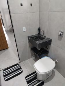 a bathroom with a sink and a toilet at Espaço Aconchegante e Moderno in Primavera do Leste