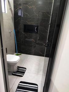 a bathroom with a toilet and a glass shower door at Espaço Aconchegante e Moderno in Primavera do Leste