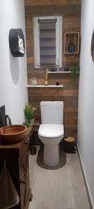 a bathroom with a white toilet in a room at Le Mimosa in Cricquebœuf