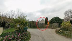 a red circle on a fence in a yard at Le Mimosa in Cricquebœuf +1 photo