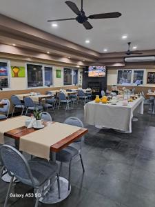 a restaurant with tables and chairs and a ceiling fan at La Mision Posadas in Posadas