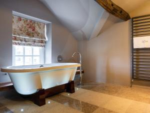 a large bath tub in a room with a window at Prospect House in Windermere