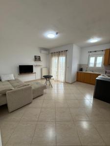 a living room with a couch and a table at Apartment Deniz in Nea Peramos