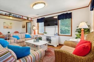 a living room with couches and a tv at Doris's Day in Duck
