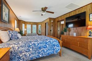 a bedroom with a blue and white bed and a tv at Doris's Day in Duck