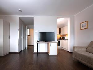 a living room with a couch and a flat screen tv at Hotel Haus Arenberg in Salzburg