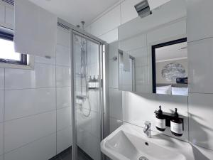 a white bathroom with a sink and a shower at Lyngen Experience Lodge in Nord-Lenangen +69 photos