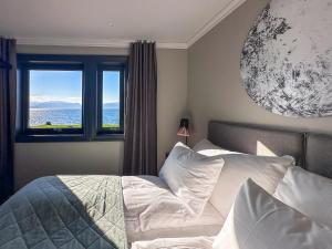 a bedroom with a bed with a view of the ocean at Lyngen Experience Lodge in Nord-Lenangen