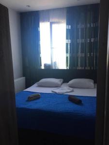 a bedroom with a blue bed with two shoes on it at Deako in Kobuleti