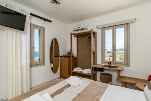 a bedroom with a bed and two windows at Iliovasilema Studios in Mytakas