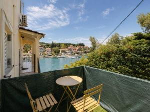 two chairs and a table on a balcony with a river at Virginia's Penthouse in Kassiopi